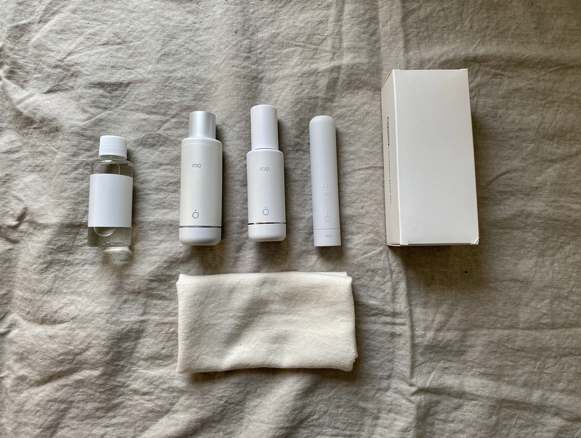 Minimalist flat lay of discreet personal wellness devices, water-based lubricant, cotton cloth and unbranded packaging on linen sheet — showing body-safe male stroker materials in Malaysia